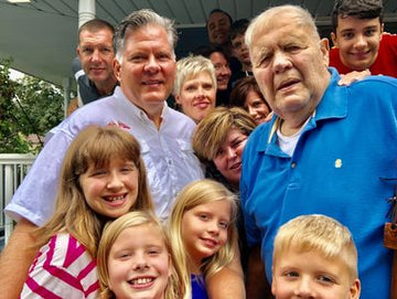Group of people posing together outdoors, including children and adults.